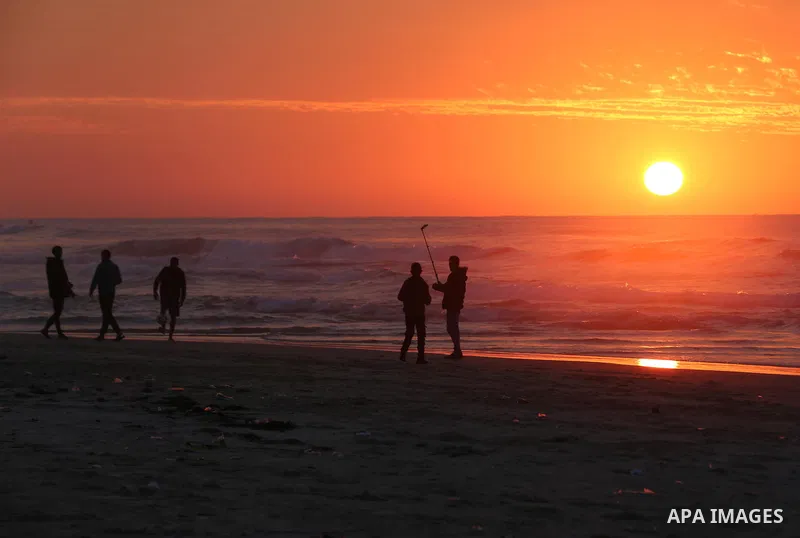Palestinians enjoy their time on the beach during sunset in the last day of 2018, a few hours prior to the new year's celebrations, in Gaza city on December 31, 2018. Photo by Ashraf Amra