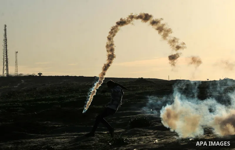 Palestinian protesters clash with Israeli troops following the tents protest where Palestinians demand the right to return to their homeland at the Israel-Gaza border, in al-Bureij in the center of Gaza Strip on January...
