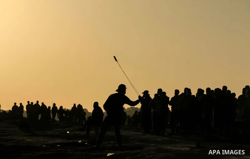 Palestinian protesters clash with Israeli troops following the tents protest where Palestinians demand the right to return to their homeland at the Israel-Gaza border, in al-Bureij in the center of Gaza Strip on January...