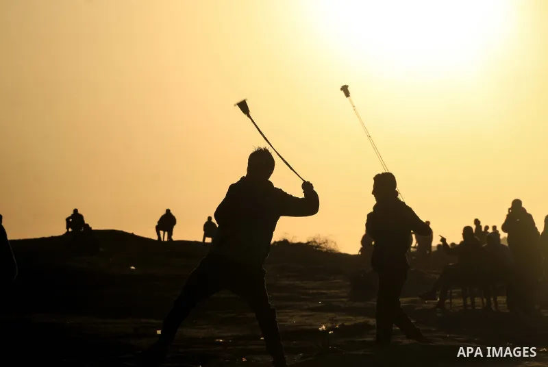 Palestinian protesters clash with Israeli troops following the tents protest where Palestinians demand the right to return to their homeland at the Israel-Gaza border, in al-Bureij in the center of Gaza Strip on January...