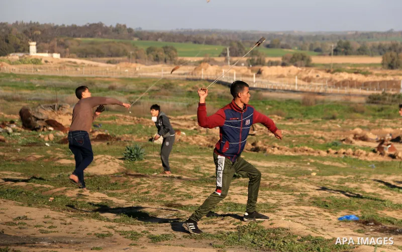 Palestinian protesters clash with Israeli troops following the tents protest where Palestinians demand the right to return to their homeland at the Israel-Gaza border, in al-Bureij in the center of Gaza Strip on January...