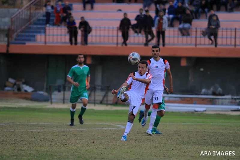 Palestinian Etihad al-Shujaiya players (green T-shirt) and Shabab Khanyounis players (whiteT-shirt) compete during a local competition, at Palestine Stadium, in Gaza City on January 20, 2019. The match ende 2-1 to Shabab...