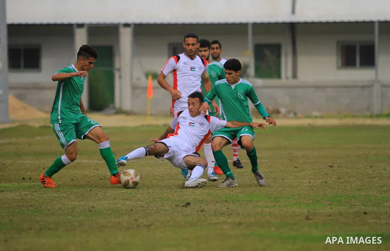 Palestinian Etihad al-Shujaiya players (green T-shirt) and Shabab Khanyounis players (whiteT-shirt) compete during a local competition, at Palestine Stadium, in Gaza City on January 20, 2019. The match ende 2-1 to Shabab...