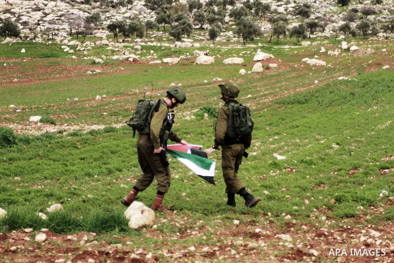 Israeli security forces take remove a Palestinian flag during clashes with Palestinian protesters in al-Mughayar village, near the West Bank city of Ramallah, February 01, 2019. Photo by Ahmad Arouri
