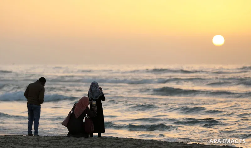 Palestinian youth take a photo along the Mediterranean coast during the sunset at the beach of Gaza city, February 12, 2019. Photo by Mahmoud Naser