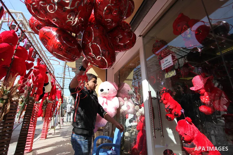 Palestinian vendors display flowers, red teddy bears, red ballons and pillows on Valentine's day, in Gaza city on February 14, 2019. Valentine's Day is increasingly popular in the region as people have taken up the custo...