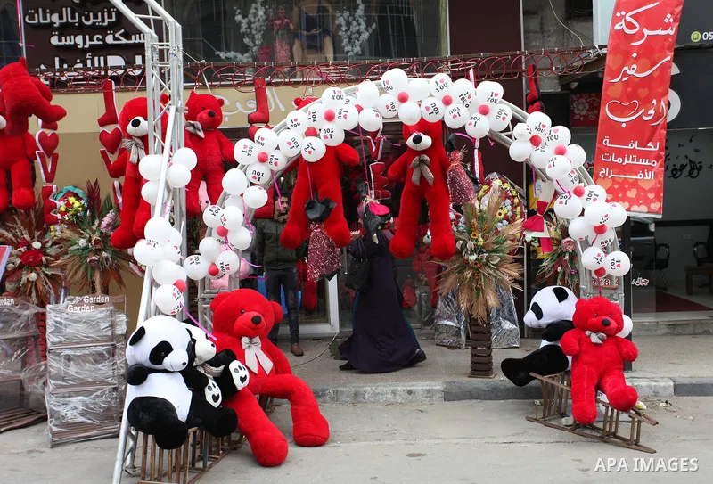 Palestinian vendors display flowers, red teddy bears, red ballons and pillows on Valentine's day, in Gaza city on February 14, 2019. Valentine's Day is increasingly popular in the region as people have taken up the custo...