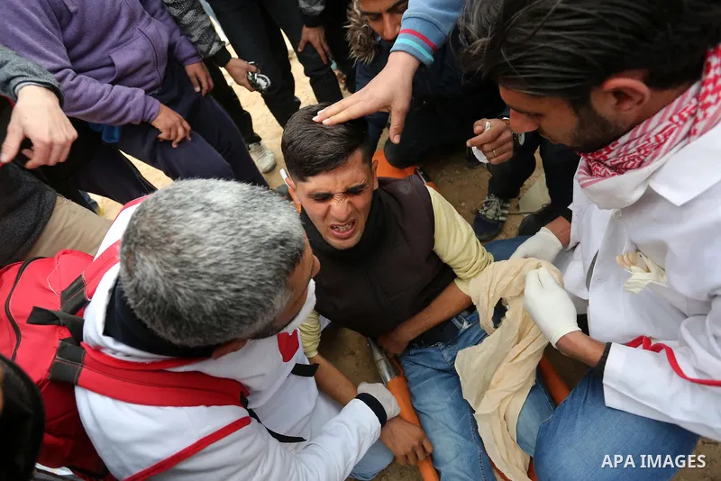 Paramedicals carry a wounded Palestinian protester, who was injured by Israeli security forces at the Gaza-Israel maritime border, during clashes across from the Israeli settlement of Kibbutz Zikim, on February 19, 2019,...