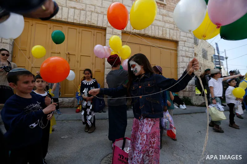 Israeli settlers celebrate the Jewish holiday of Purim, in the West Bank city of Hebron, on March 21, 2019. Purim is a celebration of the Jews' salvation from genocide in c, as recounted in the Book of Esther. Photo by W...