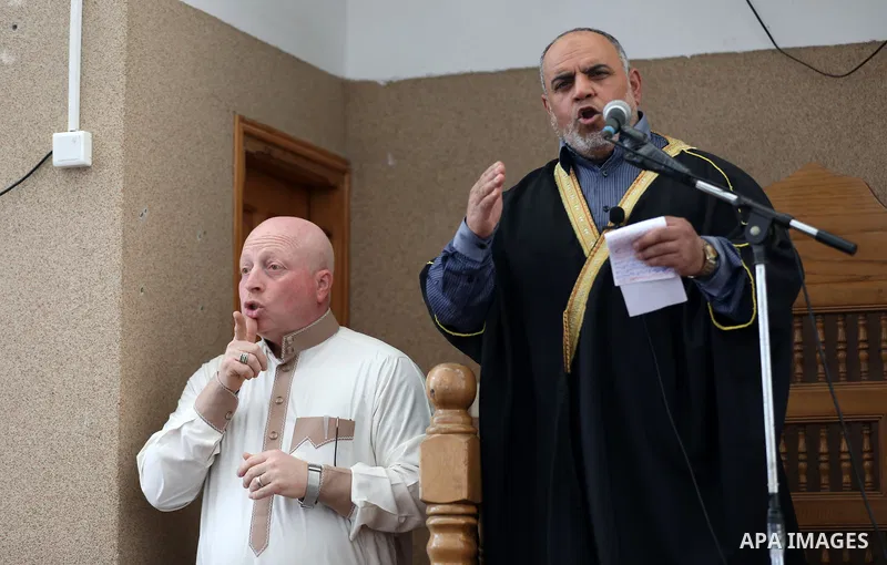 Mohammed Abu Ghola (L), a Palestinian sign language trainer, translates into sign language to deaf muslim worshipers during Friday prayers, at a mosque in al-Zawaydah destrict, in the central Gaza Strip, March 22, 2019....