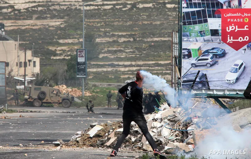 Palestinian students from Birzeit University take cover during clashes with Israeli security forces at Beit El checkpoint, near the West Bank city of Ramallah, 27 March 2019. Palestinian students from Birzeit University...