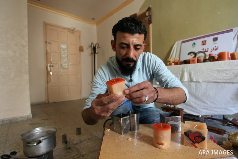 Bassam Hmaid, a 36 Palestinian man, uses wax to form candles, at his home, in Gaza city, April 20, 2019. In the developed world today, candles are used mainly for their aesthetic value and scent, particularly to set a so...