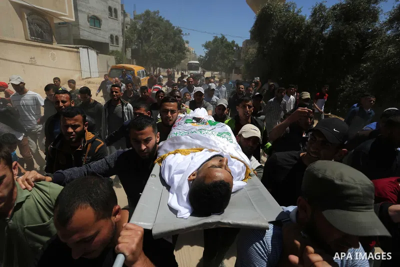 Mourners carry the body of Palestinian Abdullah Abdelal, 24, who was shot dead by Israeli forces at the Israel-Gaza border, during his funeral in Rafah in the southern of Gaza strip, on May 11, 2019. Photo by Ashraf Amra