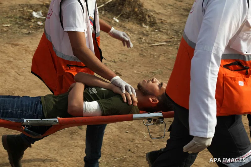 A wounded Palestinian protester is evacuated during clashes with Israeli troops following the tents protest where Palestinians demand the right to return to their homeland at the Israel-Gaza border, in Janalia in the nor...