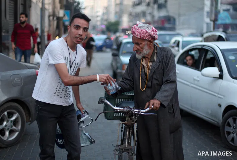 A Palestinian christian man distributes dates and water for Muslims, just before breaking their fast during the holy fasting month of Ramadan, in Gaza city on June 2, 2019. Muslims around the world celebrate the holy mon...