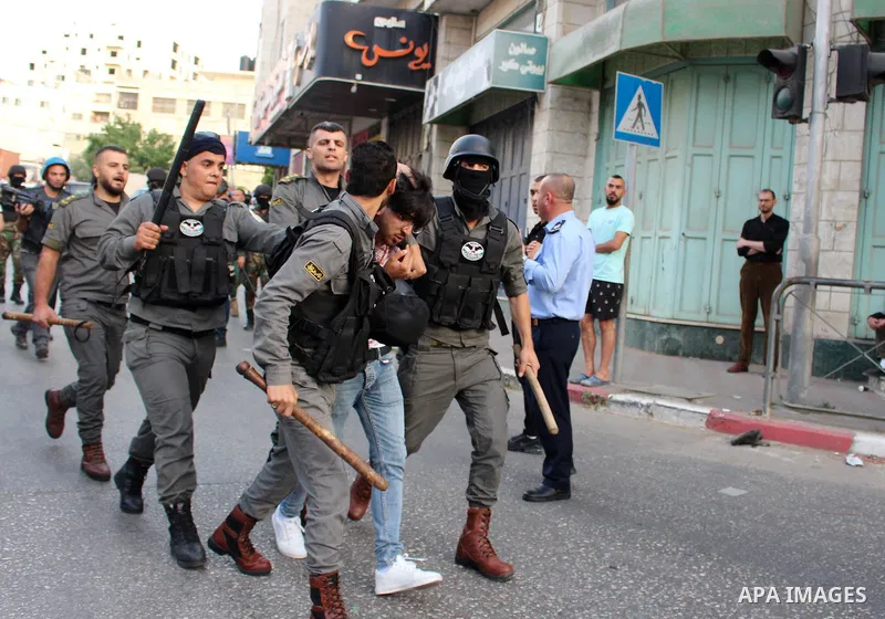 Members of Palestinian security forces detain a supporter of Hizb-ut Tahrir party as he tries with others to perform Eid al-Fitr prayer, opposing the Grand Mufti of Jerusalem who officially announced that the Muslim holi...