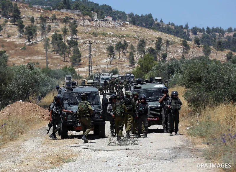 Israeli security forces take position during clashes with Palestinian protesters following a protest against the expropriation of Palestinian agricultural land by Israel, in the village of Azmut, near the West Bank city...