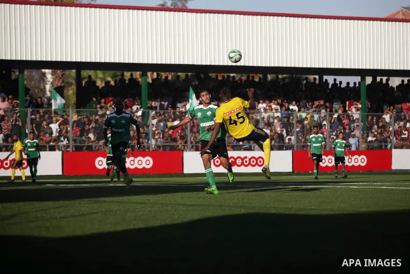 Palestinian players of Khadamat Rafah club (green T-shirt), and players of Shabab Balata club (yellow T-shirt), play during the Palestine cup championship, in Rafah in the southern Gaza Strip on June 30. 2019. The game e...