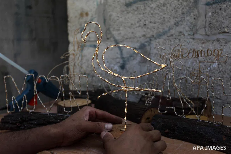 Muath Abu el-Qumboz, 24, A Palestinian man works on handmade gifts at his house, in Gaza city on July 02, 2019. Abu el-Qumboz, uses wood and wires to form different shapes and make lighten gifts from simple materials. Ph...