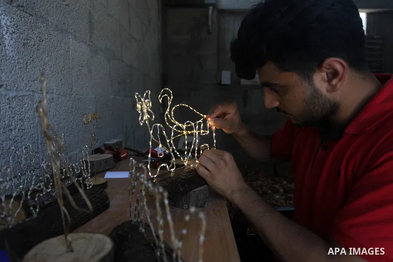 Muath Abu el-Qumboz, 24, A Palestinian man works on handmade gifts at his house, in Gaza city on July 02, 2019. Abu el-Qumboz, uses wood and wires to form different shapes and make lighten gifts from simple materials. Ph...