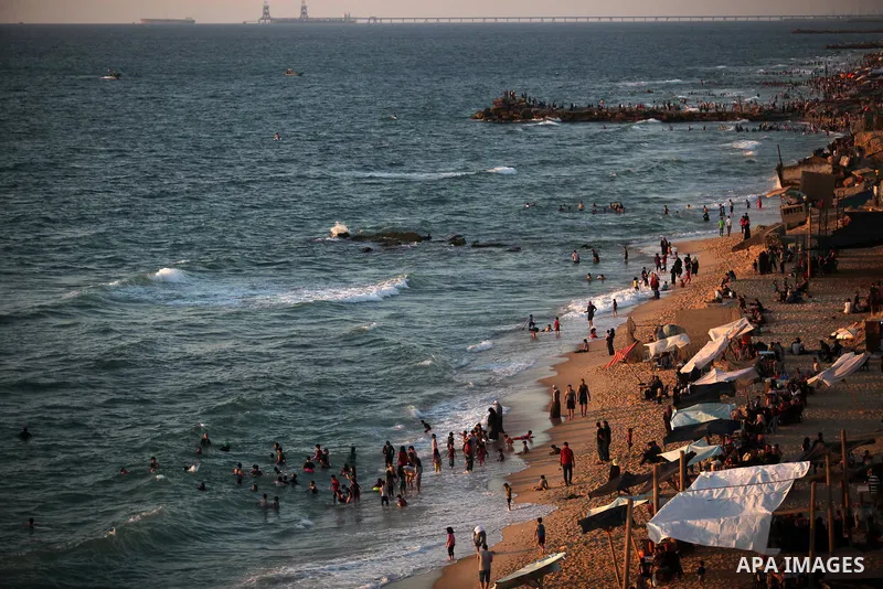 Palestinians enjoy at the beach along the shore of the Mediterranean Sea during the sunset, in Gaza City July 05, 2019. Photo by Mahmoud Ajjour