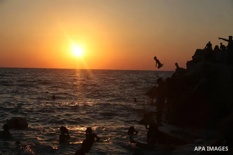 Palestinians enjoy at the beach along the shore of the Mediterranean Sea during the sunset, in Gaza City July 05, 2019. Photo by Mahmoud Ajjour