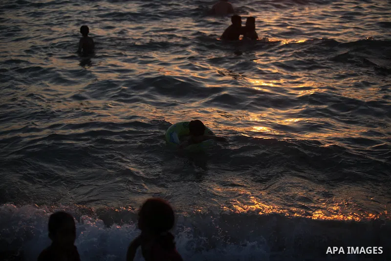 Palestinians enjoy at the beach along the shore of the Mediterranean Sea during the sunset, in Gaza City July 05, 2019. Photo by Mahmoud Ajjour