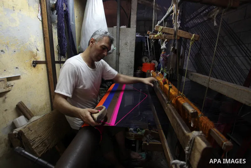 Palestinian workers weave carpets in a workshop in Gaza city on July 06, 2019. Weaving sheep's wool into traditional carpets is one oldest professions, it takes skill, patience and steady hand. Photo by Mahmoud Ajjour