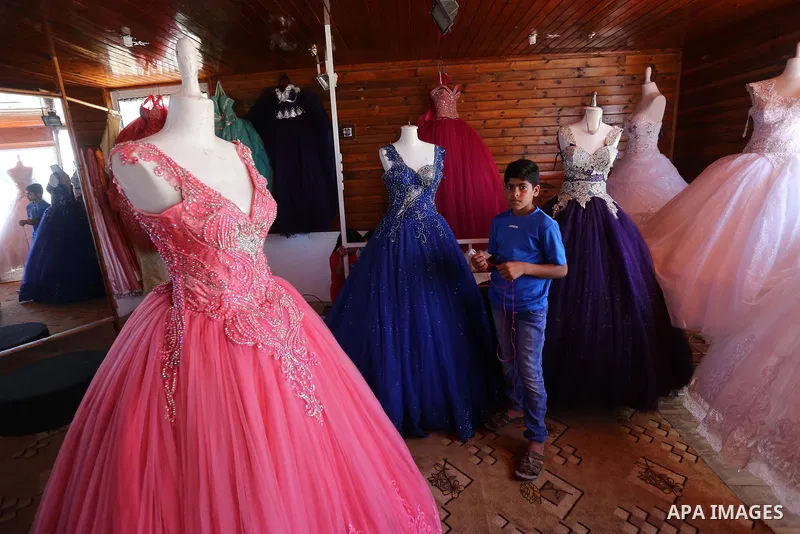 Palestinian woman Sabrin al-Jabri, 34, works with her children at her shop in renting and selling wedding dresses, in Khan Younis in the southern Gaza Strip, July 06, 2019. Al-Jabri graduated from the Department of Medic...