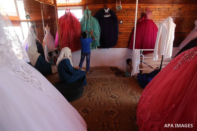Palestinian woman Sabrin al-Jabri, 34, works with her children at her shop in renting and selling wedding dresses, in Khan Younis in the southern Gaza Strip, July 06, 2019. Al-Jabri graduated from the Department of Medic...