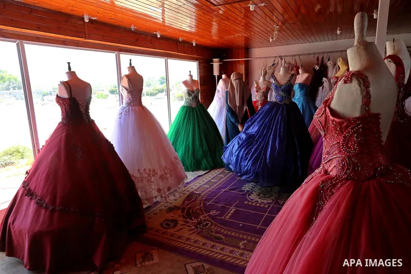Palestinian woman Sabrin al-Jabri, 34, works with her children at her shop in renting and selling wedding dresses, in Khan Younis in the southern Gaza Strip, July 06, 2019. Al-Jabri graduated from the Department of Medic...