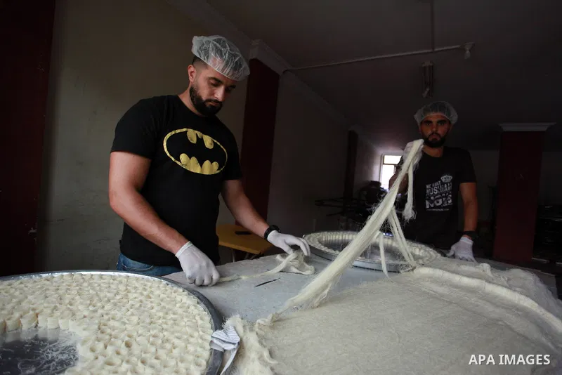 Palestinian workers prepare sweets ahead of the results of high school exams, known as ''Tawjihi'', at a workshop in Gaza city, July 17, 2019. Photo by Mahmoud Ajjour