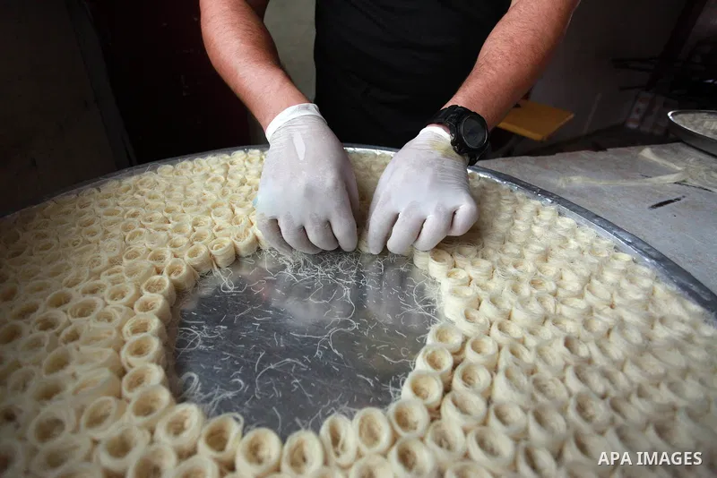 A Palestinian worker prepares sweets ahead of the results of high school exams, known as ''Tawjihi'', at a workshop in Gaza city, July 17, 2019. Photo by Mahmoud Ajjour