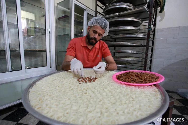 A Palestinian worker prepares sweets ahead of the results of high school exams, known as ''Tawjihi'', at a workshop in Gaza city, July 17, 2019. Photo by Mahmoud Ajjour