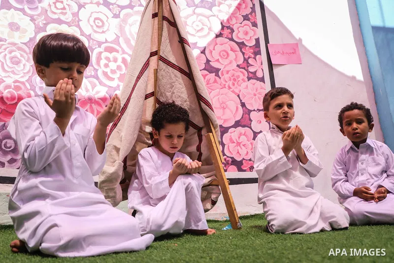 Palestinian children gather around a makeshift cube representing the holy Kaaba, as part of training children how to perform Hajj pilgrimage, in Gaza city on August 06, 2019. Muslims from around the world flood Saudi cit...