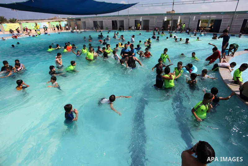 Palestinian children enjoy swimming in a pool at Sharm Park in Gaza city on August 06, 2019. Photo by Mahmoud Ajjour