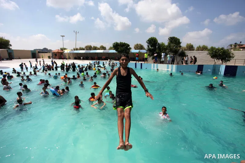 Palestinian children enjoy swimming in a pool at Sharm Park in Gaza city on August 06, 2019. Photo by Mahmoud Ajjour