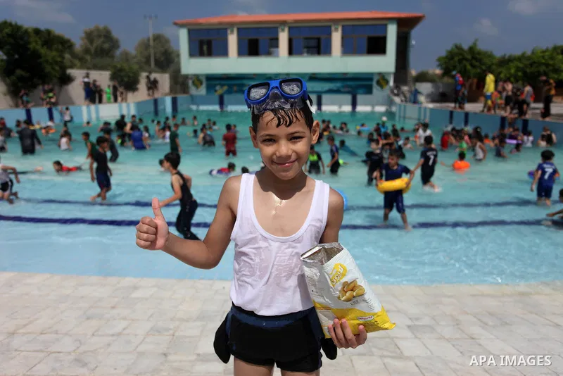 Palestinian children enjoy swimming in a pool at Sharm Park in Gaza city on August 06, 2019. Photo by Mahmoud Ajjour