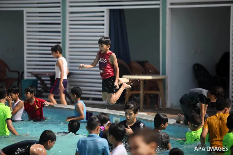 Palestinian children enjoy swimming in a pool at Sharm Park in Gaza city on August 06, 2019. Photo by Mahmoud Ajjour