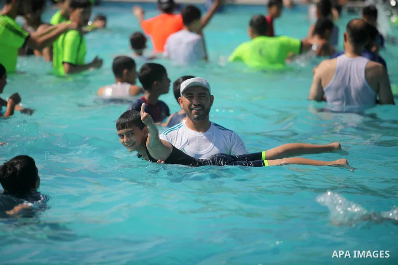 Palestinian children enjoy swimming in a pool at Sharm Park in Gaza city on August 06, 2019. Photo by Mahmoud Ajjour