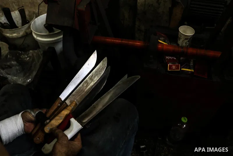 A Palestinian worker sharps knives at a workshop ahead of Eid al-Adha in Gaza city on August 7, 2019. The knives use to slaughter cattle and sheep for the Muslim holiday of Eid al-Adha or the Feast of Sacrifice, which ma...
