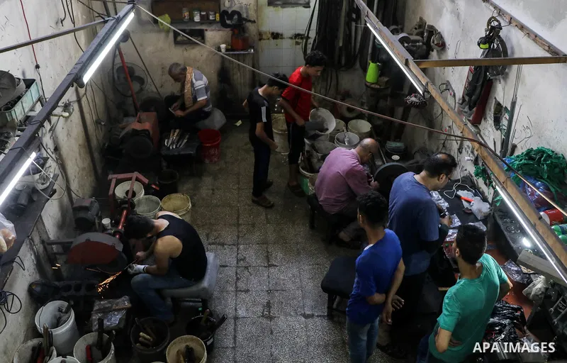Palestinian workers sharp knives at a workshop ahead of Eid al-Adha in Gaza city on August 7, 2019. The knives use to slaughter cattle and sheep for the Muslim holiday of Eid al-Adha or the Feast of Sacrifice, which mark...