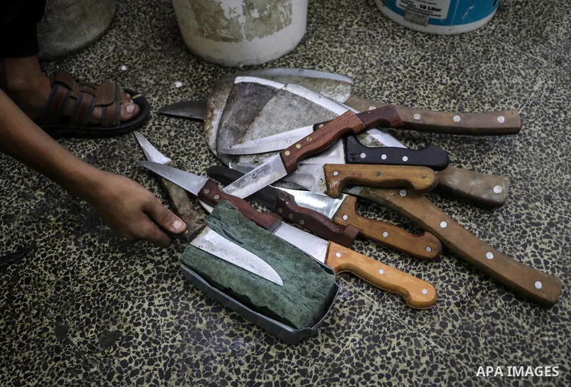 A Palestinian worker sharps knives at a workshop ahead of Eid al-Adha in Gaza city on August 7, 2019. The knives use to slaughter cattle and sheep for the Muslim holiday of Eid al-Adha or the Feast of Sacrifice, which ma...
