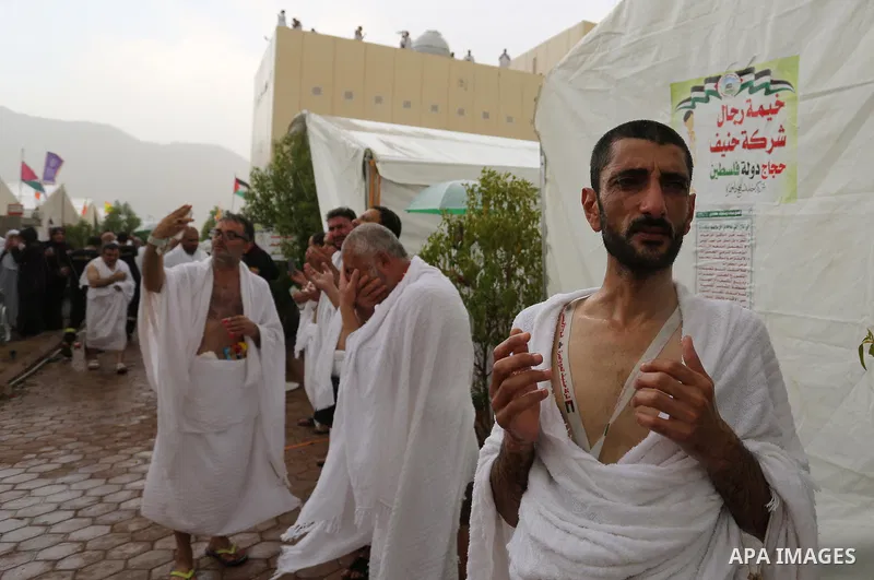 Palestinian piligrims gather near their tents during a rainy and windy weather weather, as they take part in one of the Hajj rituals southeast of the Saudi holy city of Mecca on August 10, 2019. More than 2 million pilgr...