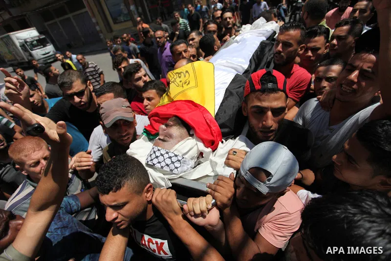 Mourners carry the body of Palestinian Mohammed al-Taramsi, one of three armed Palestinians killed overnight in Israeli fire along the border with the Gaza Strip, mourn during his funeral in Beit Lahya in northern Gaza s...