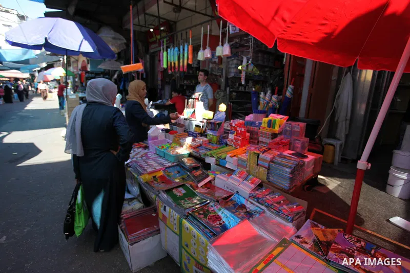 Palestinians shop at a market during preparation for the new school year in Gaza city, on August 22, 2019. Photo by Mahmoud Ajjour