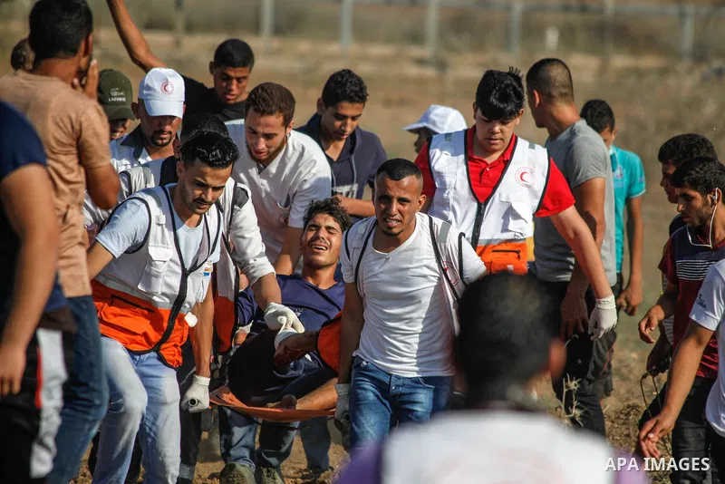 A wounded Palestinian protester is evacuated during clashes with Israeli troops following the tents protest where Palestinians demand the right to return to their homeland at the Israel-Gaza border, in Jabalia in the nor...