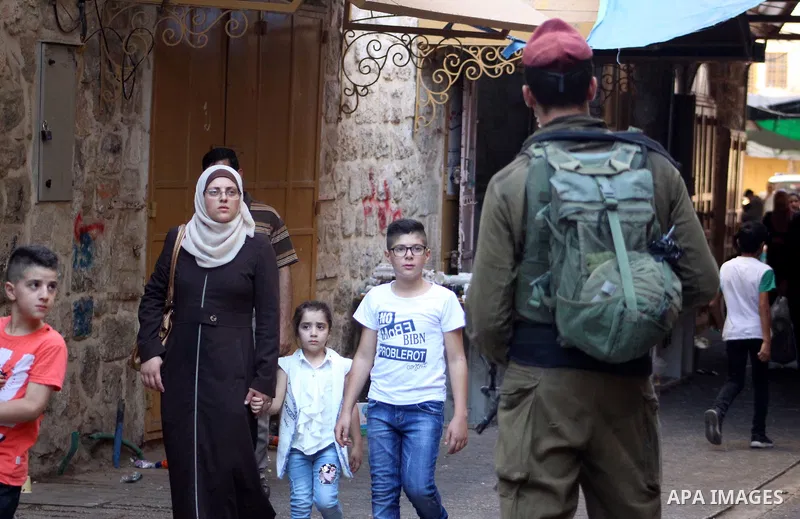 Israeli soldiers stand guard as Jewish settlers tour of the streets in the Old City of the West Bank city of Hebron, on August 24, 2019. Photo by Mosab Shawer