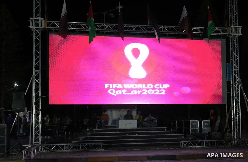 Palestinians gather in Gaza city as the official logo of the FIFA World Cup Qatar 2022 is projected on a screen on September 3, 2019. Qatar unveiled the logo for the 2022 World Cup which will be hosted by the Gulf emirat...