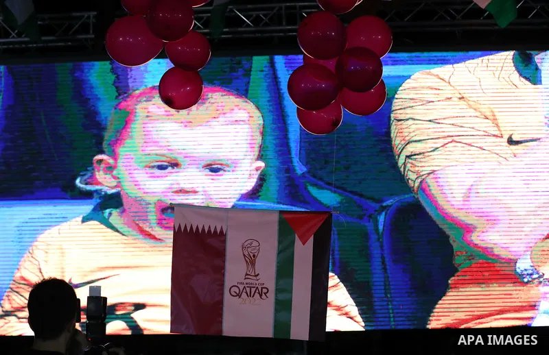 Palestinians gather in Gaza city as the official logo of the FIFA World Cup Qatar 2022 is projected on a screen on September 3, 2019. Qatar unveiled the logo for the 2022 World Cup which will be hosted by the Gulf emirat...